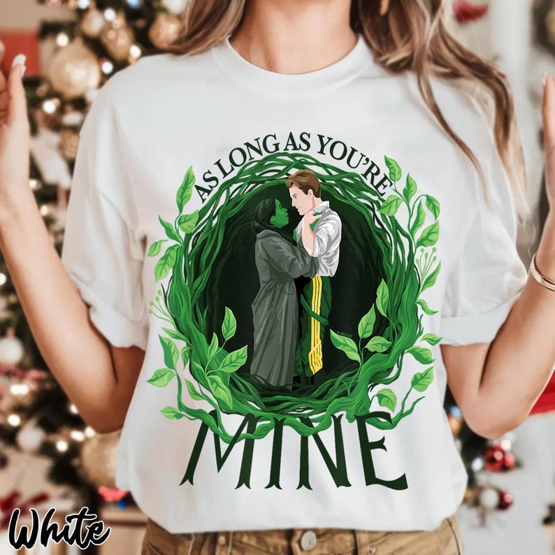 May include: White t-shirt with a graphic of two figures embracing within a green leafy wreath. The text "AS LONG AS YOU'RE" arches above the figures, with "MINE" below. The word "White" is printed in the bottom left corner.