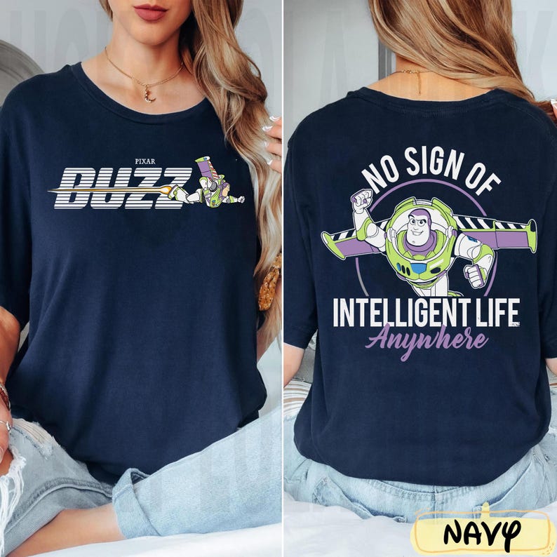 May include: Navy blue t-shirt featuring Buzz Lightyear from Pixar's Toy Story. The front displays "BUZZ" with a graphic, while the back reads "NO SIGN OF INTELLIGENT LIFE Anywhere" with a Buzz Lightyear graphic. The word "NAVY" is at the bottom.