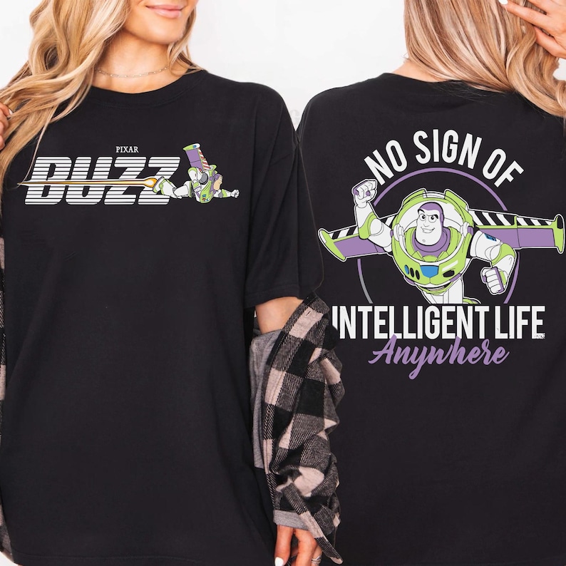 May include: Black t-shirt featuring Buzz Lightyear from Pixar's Toy Story. The front graphic displays "Buzz" in a stylized font with Buzz in flight. The back graphic reads "No Sign of Intelligent Life Anywhere" with Buzz in a flying pose.