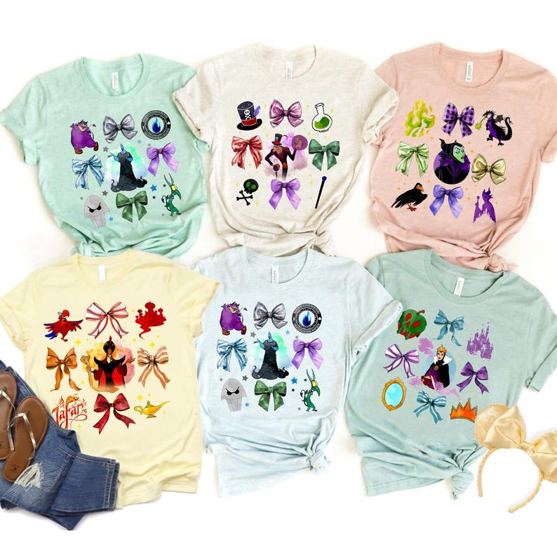 May include: A collection of six short-sleeved t-shirts in various pastel colors. Each shirt features a unique design of cartoon characters, bows, and other themed graphics. The shirts are displayed on a white background.
