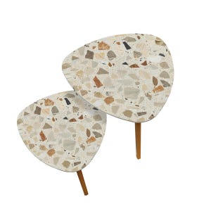 May include: Two terrazzo-topped side tables with a unique triangular shape. The tables feature a speckled pattern in beige, brown, and black. Each table has three wooden legs, adding a touch of warmth to the design.