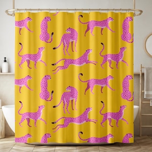 May include: A yellow shower curtain featuring a repeating pattern of pink cheetahs with black spots. The cheetahs are depicted in various poses, including running and standing. The curtain is hanging in a bathroom setting.