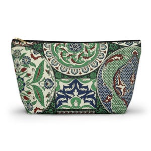 Könnte beinhalten: Eine Reißverschlusstasche mit einem mehrfarbigen Muster aus kreisförmigen und geometrischen Motiven in Grün-, Blau-, Rot- und Cremetönen. Das Design umfasst komplexe florale Elemente, gebogte Kanten und detaillierte botanische Illustrationen.