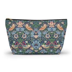 May include: A zipped cosmetic bag featuring a repeating pattern of birds, flowers, and berries in blue, green, and peach hues. The bag has a gold zip and black trim. The design is reminiscent of vintage botanical illustrations.
