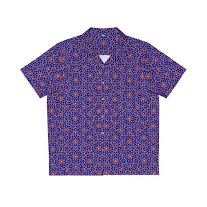 May include: A short-sleeved button-down shirt with a vibrant blue background and a repeating pattern of red and white floral-like shapes. The shirt has a classic collar and a relaxed fit, suitable for casual wear.