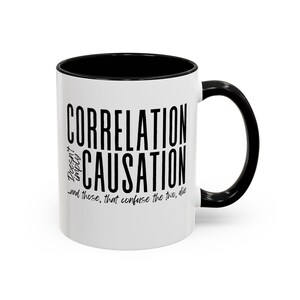 May include: White ceramic mug with a black rim and handle. The mug has black text that reads "Correlation Doesn't Imply Causation...and those that confuse the two, die."