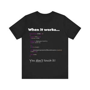 May include: Black t-shirt with white text that reads "When it works..." and includes a code snippet in purple text. The code snippet includes the text "You don't touch it!"