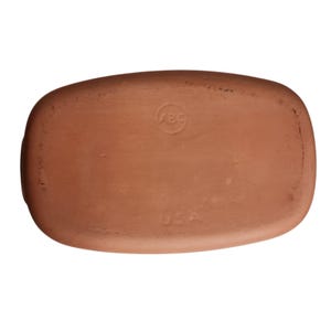 May include: A rectangular, terracotta-colored ceramic tray. The underside features a circular stamp with the letters "ABC" and the word "USA" stamped below. The tray has rounded corners and a slightly textured surface.