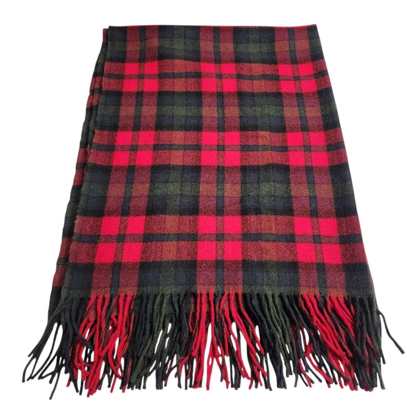 May include: A red, black, and green tartan scarf with fringed edges. The scarf displays a traditional plaid design, with a vibrant red as the primary colour, contrasted by black and green. The fringing at the ends is a mix of red and black.