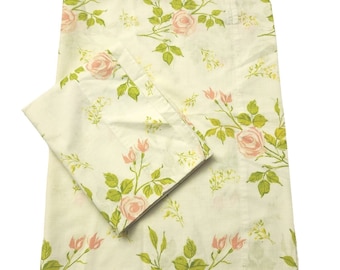 May include: A set of two white cotton pillowcases with a pink rose floral pattern. The pillowcases have a subtle green leaf design.