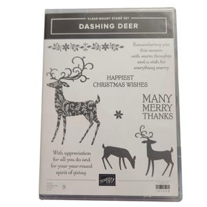Op de afbeelding: Transparante stempelset getiteld "Dashing Deer". De set bevat illustraties van herten met bloemmotieven en tekst die luidt "Happiest Christmas Wishes" en "Many Merry Thanks". Bevat extra tekst: "With appreciation for all you do and for your year-round spirit of giving."