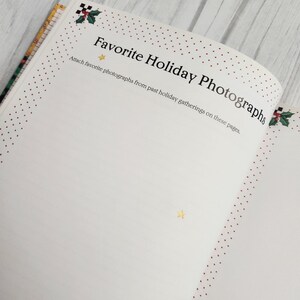 May include: A white page with red polka dots around the edges. The page has the text "Favorite Holiday Photographs" and instructions to attach favorite photographs from past holiday gatherings on these pages.