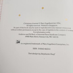 May include: A book cover with a white background and gold stars. The title "Christmas Journal" is printed in black text. The book was published in 1994 by Mary Engelbreit Ink. The copyright information includes the text "All rights reserved. Printed in Singapore."