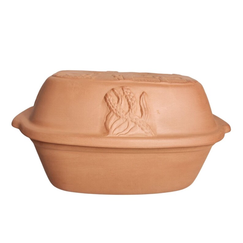 May include: A terracotta-colored, oval-shaped baking dish with a lid. The lid features a raised relief of an octopus. The dish has a wide, shallow base and a rounded top, suitable for baking and serving.