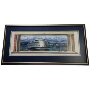 May include: A framed print of a vintage illustration depicting a large, silver ferry boat sailing past a mountain range. The boat has a rounded bow and multiple portholes. The scene is set in a harbor with a city skyline in the background.