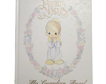 May include: A hardcover book titled "Precious Moments" with a drawing of an angel inside a floral wreath. The angel has blonde hair, a halo, and is wearing a white robe. The text "My Guardian Angel" is below the drawing.