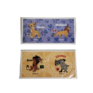 May include: Four round stickers featuring characters from the Disney movie The Lion King. The stickers are on a white background with a blue and yellow border. The characters are Simba, Mufasa, Scar, and Shenzi. Each sticker has a number on it.