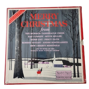 Könnte beinhalten: Ein Vintage-Vinyl-Schallplattencover mit dem Titel "MERRY CHRISTMAS" in roten Buchstaben. Das Cover zeigt eine Winterlandschaft mit Bäumen, einer Kirche und einem roten Schlitten. Das Album enthält Künstler wie Doris Day.