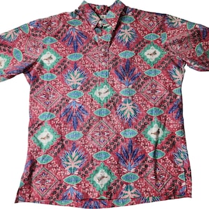 Puede incluir: Una camisa roja con botones y un patrón detallado con motivos florales y de pájaros azules, verdes y blancos. La camisa tiene mangas largas y cuello. La tela tiene una apariencia texturizada.