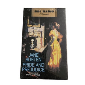 May include: A cassette tape case featuring a painting of a woman in a yellow dress standing in a room with a fireplace. The text on the case reads "BBC Radio Presents Jane Austen Pride and Prejudice Performance by Patricia Hodge".