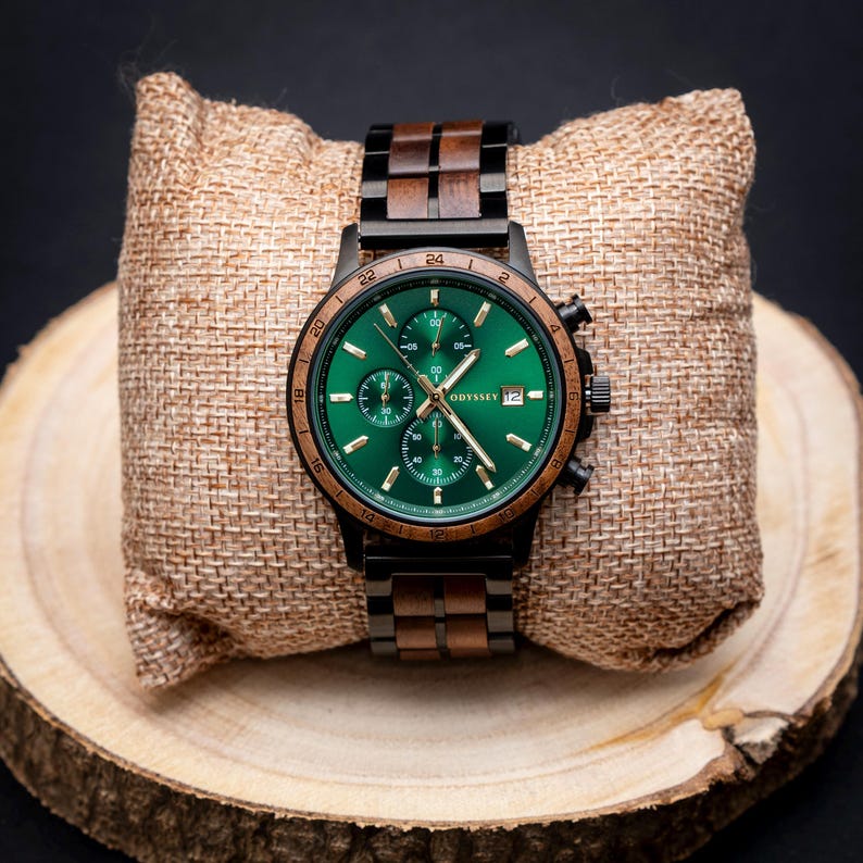 A beautiful wooden watch, with green face surrounded by a walnut bezel accompanied by a walnut and black stainless steel strap. On a display cushion on a round of wood.