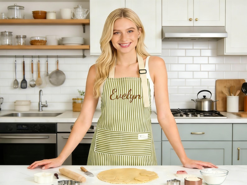 Puede incluir: Una taza de cer&aacute;mica blanca con un asa negra y el texto "But First, Coffee" en negrita negra. La taza se encuentra sobre un fondo borroso, sugiriendo un ambiente acogedor.