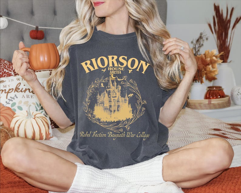 a woman sitting on a bed with a shirt on