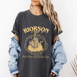 a woman wearing a black shirt with a castle on it