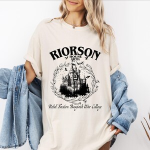 a woman wearing a white shirt with a castle on it