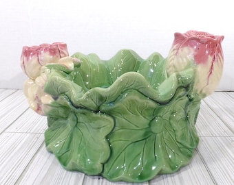 Centro de mesa o cuenco de cerámica vintage tipo mayólica con flores de loto rosa y hojas verdes.