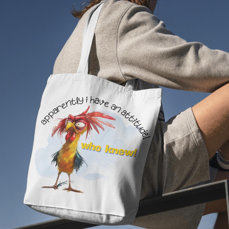 Puede incluir: Bolsa de tela blanca con una ilustraci&oacute;n de gallo de dibujos animados y el texto "&iexcl;aparentemente tengo una actitud! &iexcl;qui&eacute;n lo sab&iacute;a!"
