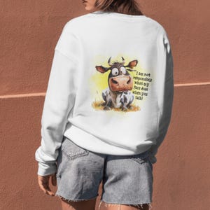 May include: White sweatshirt with a cartoon cow illustration and the text "I am not responsible what my face does when you talk!"
