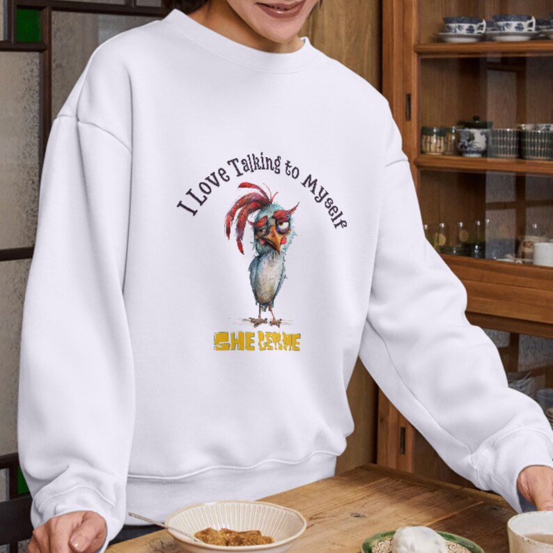 May include: White sweatshirt with a cartoon chicken wearing glasses and the text "I love talking to myself" and "She Derme" in yellow letters.