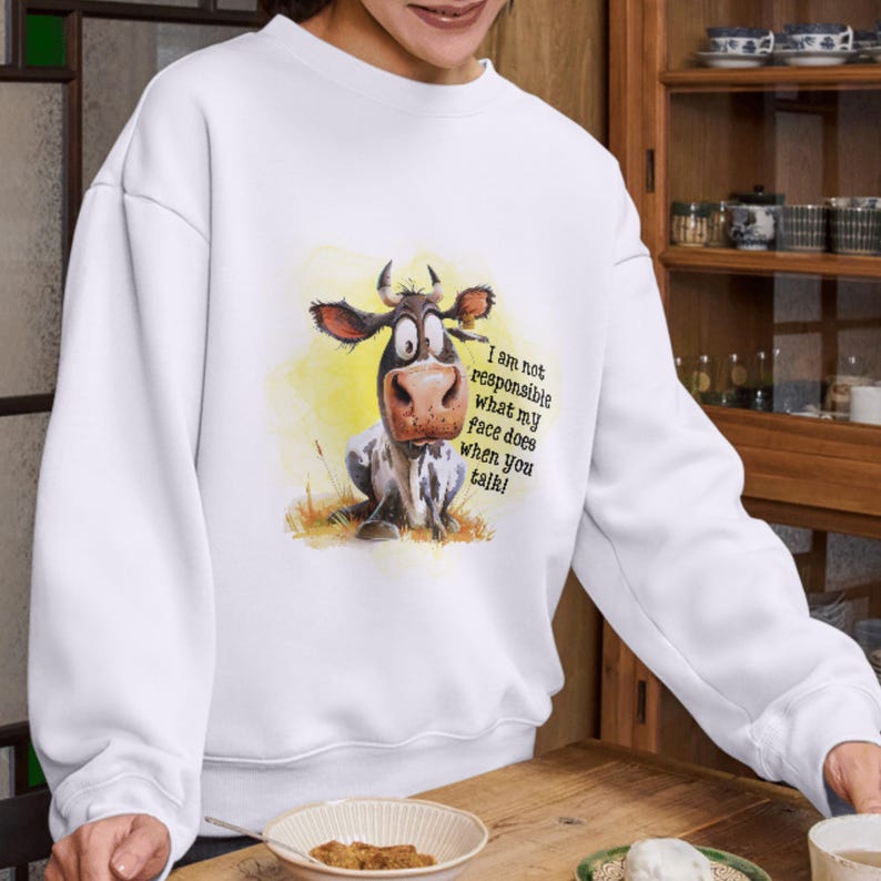 May include: White sweatshirt with a cartoon cow illustration and the text "I am not responsible what my face does when you talk!"