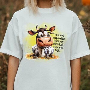 May include: White t-shirt with a cartoon cow illustration and the text "I am not responsible what my face does when you talk!"