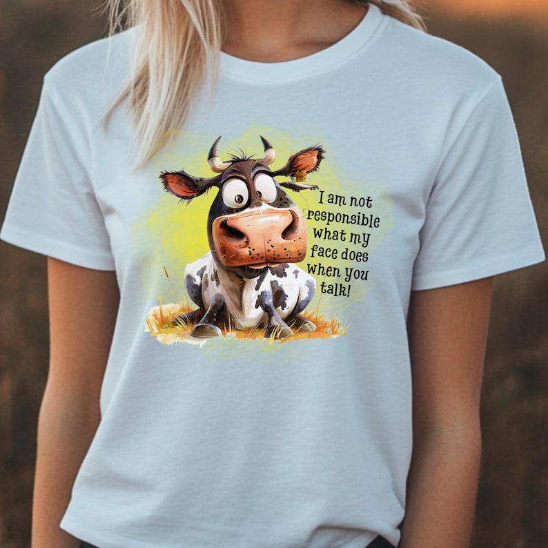 May include: A light blue t-shirt with a cartoon cow illustration and the text "I am not responsible what my face does when you talk!"