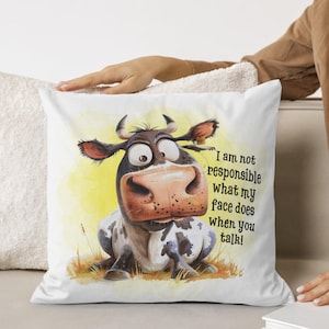May include: White pillow with a cartoon cow with black and white spots and the text "I am not responsible what my face does when you talk!"