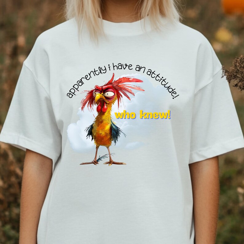 Puede incluir: Camiseta blanca con una ilustraci&oacute;n de gallo de dibujos animados y el texto "&iexcl;aparentemente tengo una actitud! &iexcl;qui&eacute;n lo sab&iacute;a!"