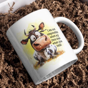 May include: White ceramic mug with a cartoon cow with a surprised expression. The mug has the text "I am not responsible what my face does when you talk!" printed on it.