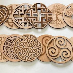 May include: A collection of laser-cut wooden coasters featuring various Celtic and nature-inspired designs. The coasters include heart-shaped knots, crosses, tree of life, and clover patterns. The natural wood color provides a rustic and decorative appeal.