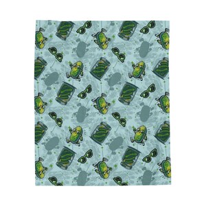 May include: A light blue blanket featuring a repeating pattern of cartoon pickles wearing sunglasses, pickle jars, and sunglasses. The design has a whimsical, playful theme.