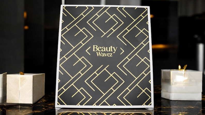 May include: A black and gold sign with a geometric pattern and the text "Beauty Wavez".