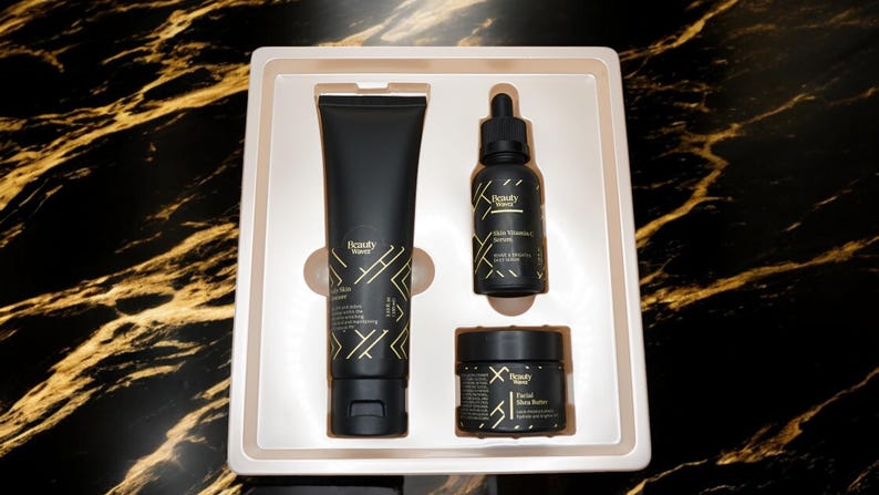 May include: A black and gold skincare set in a white box. The set includes a face wash, serum, and face butter. The products are labeled "Beauty Haven".