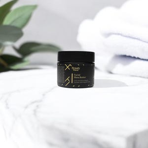 Beauty Wavez Facial Shea Butter for men displayed on a white marble edge with clean folded towels and greenery, promoting hydration and luxury self-care.