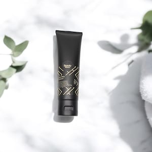 Beauty Wavez Daily Skin Cleanser on sunlit marble counter, surrounded by soft eucalyptus leaves and spa towels for a clean, minimal skincare aesthetic.