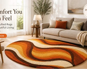May include: An oval hand-tufted rug featuring a wavy, retro-inspired pattern in shades of cream, yellow, orange, and dark brown. The rug is placed on a light wood floor in a living room setting with a sofa, chairs, and a round side table.