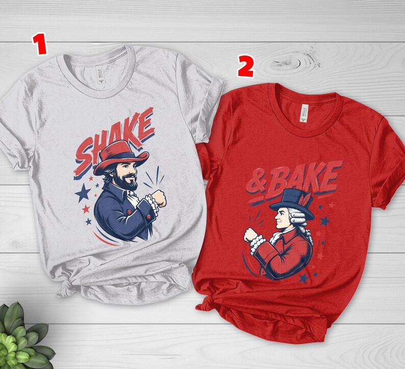 May include: A light gray t-shirt labeled 1 featuring a graphic of a man in a red hat with the text SHAKE and a red t-shirt labeled 2 featuring a graphic of a man in a blue hat with the text & BAKE, both with blue and red star accents.