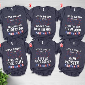 Puede incluir: Seis camisetas de manga corta gris oscuro con texto blanco y gr&aacute;ficos de fuegos artificiales rojos, blancos y azules. Cada camiseta muestra frases &uacute;nicas como Most Likely to be the Fireworks Director y Little Firecracker.