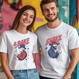 May include: Two white short-sleeved t-shirts featuring graphic prints. The left shirt displays a historical figure in a red coat with the text & BAKE. The right shirt shows a bearded figure in a blue coat with the text SHAKE, both with stars.