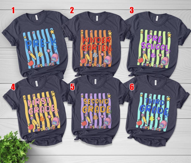 May include: Six dark gray short-sleeve t-shirts featuring school-themed graphics with vertical stripes, pencils, apples, backpacks, and stars. Each shirt displays a specific grade level from Pre-K to Third Grade and the personalized text Mrs. Alice.